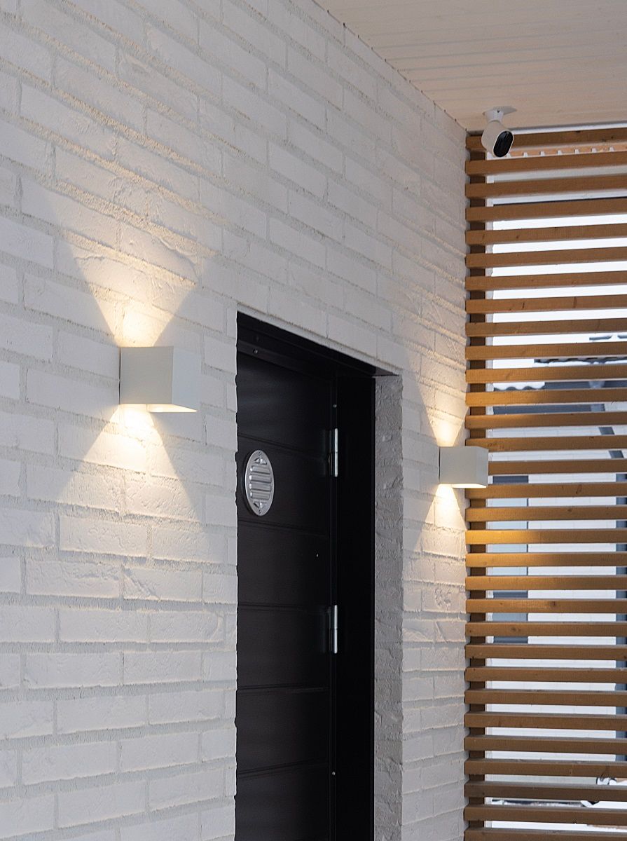 FUNK wall luminaire on both sides of an exterior door.